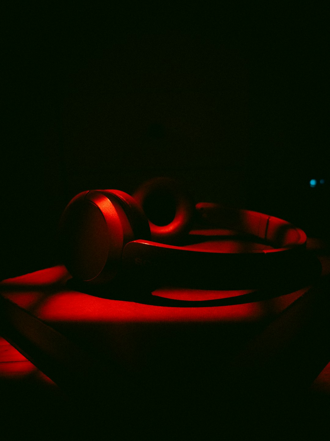 Red illuminated headphones on a dark surface, used as BMC Live Radio music imagery